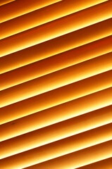 Abstract background - wooden blinds at an angle, large brown-gold horizontal stripes illuminated by the sun