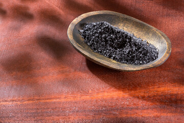 Natural black salt from Hawaii on wooden background