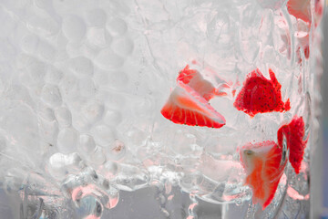 Beverage drink and ice. Texture of water drops on glass with piece of strawberry.