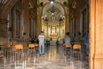 Fototapeta na wymiar Las personas están rezando en la misa de la Basílica de Zapopan. 