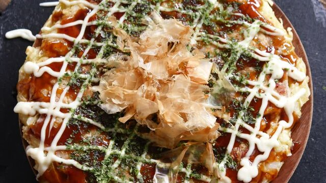 大阪名物お好み焼き。お好み焼きに乗ったかつお節が揺れてる真上からの動画。