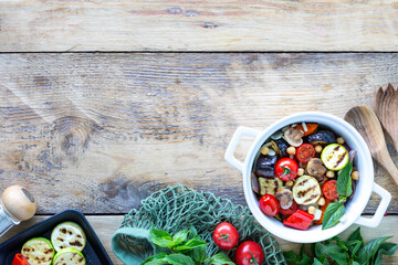 Grilled vegetables in a white ceramic pan with ingredients on a rustic background. Vegetarian food. Top view. Copy space