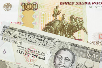 A macro image of a Russian one hundred ruble note paired up with a grey Ethiopian one birr bill.  Shot close up in macro.