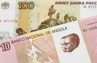 A macro image of a Russian one hundred ruble note paired up with a colorful ten kwanza bank note from Angola.  Shot close up in macro.