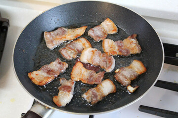 Pork belly on frying pan.