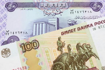 A macro image of a Russian one hundred ruble note paired up with a purple fifty dinar bill from Iraq.  Shot close up in macro.