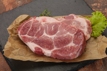 Raw pork steak over wooden board