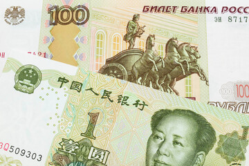 A macro image of a Russian one hundred ruble note paired up with a green and white one yuan note from China.  Shot close up in macro.