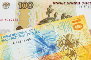 A macro image of a Russian one hundred ruble note paired up with a yellow Swiss ten franc bill.  Shot close up in macro.