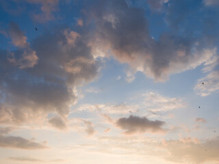 Naklejka na ściany i meble Whimsical clouds in the blue sky. Summer evening