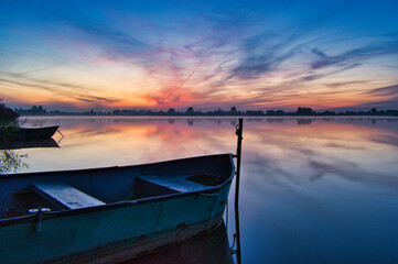 Wooden boats during the dawn on Lake Kunice