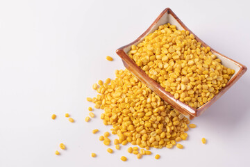 Hulled split mung bean in brown cup on white background