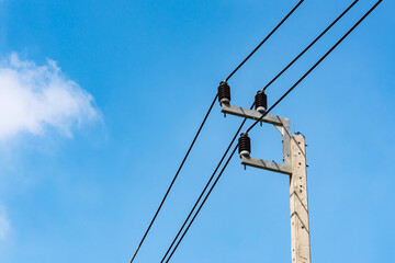 Electricity distribution post with blue sky background.