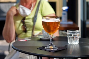 Closeup of a glass with fresh cold beer on a table