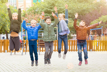 Joyful children play on street of autumn city. High quality photo