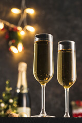 New year 2021 - two glasses of champagne on a dark background with bokeh from garlands.