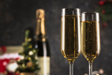 New year 2021 - two glasses of champagne on a dark background with bokeh from garlands.