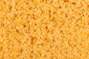 Raw farfalle pasta background. Close up of uncooked farfalle pasta. Top view