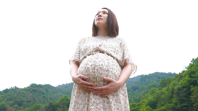 草はらを歩く若い妊婦さん