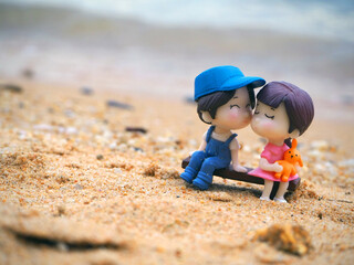 Mini focus picture of doll on sand at the beach.