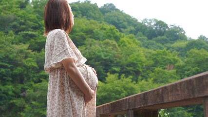 森を眺めている妊娠後期の妊婦さん