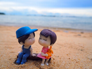 Mini focus picture of doll on sand at the beach.