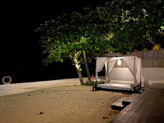 sand beach at night with white bed decoration