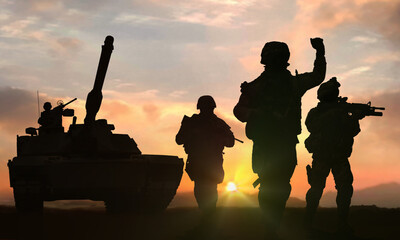 Soldiers and tank on battlefield at sunset