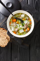 Hairst Bree is a hearty Scottish bowl of Harvest Broth or Hotch Potch close-up in a pot on the table. Vertical top view from above