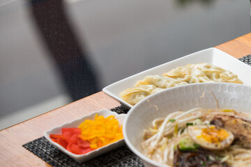 Close up image of Japanese style ramen noodle with soft boiled egg and side dish