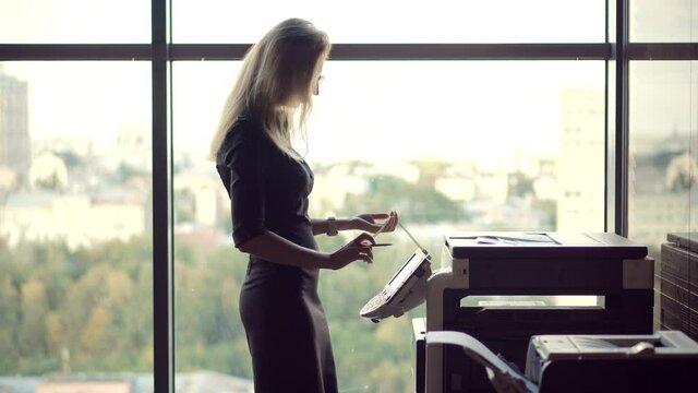 Businesswoman Using Printer In Office.Girl Using Copier For Replicate Paperwork.Woman Preparing Financial Audit Report For Marketing Strategy.Secretary Girl Sending Fax On Email And Printing Document