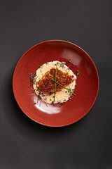 Cod piece with sauce in red deep plate