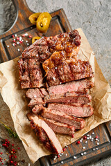 Classic ribeye steak served in waxed paper on wooden cutting board