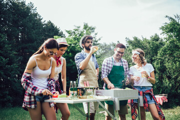 Friends having fun grilling meat enjoying bbq party