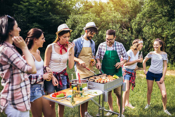 Friends having fun grilling meat enjoying bbq party