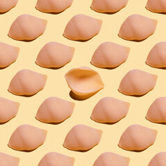 Seamless pattern with konkiloni pasta on yellow background.