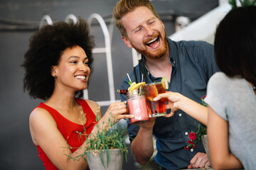 Multiracial group of friends having fun and talking in restaurant