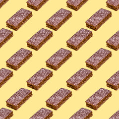Seamless pattern with chocolate cake on yellow background. Minimal food pattern.