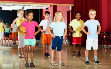 Positive little boys and beautiful girls having dancing class in studio