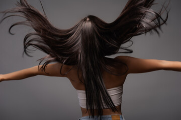 back view of brunette long haired woman isolated on black