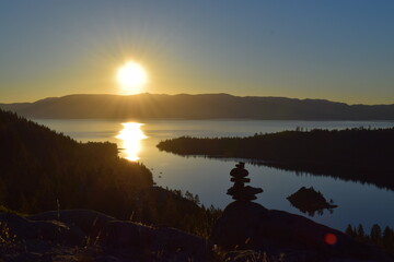 Backlit cairn at sunrise, Emerald Bay, Lake Tahoe, California, USA