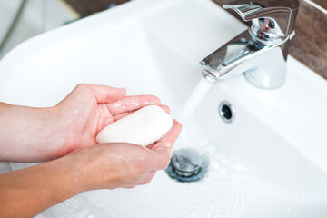 Hygiene concept. Washing hands with soap under the faucet with water
