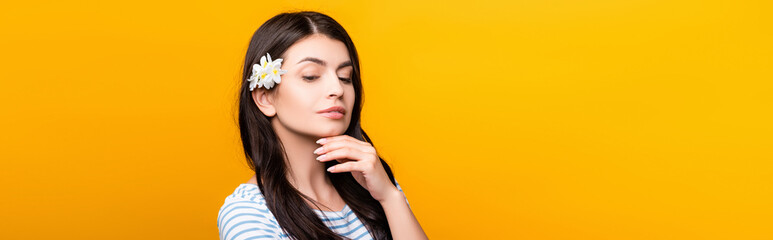 brunette young woman with flowers in hair isolated on yellow, panoramic shot