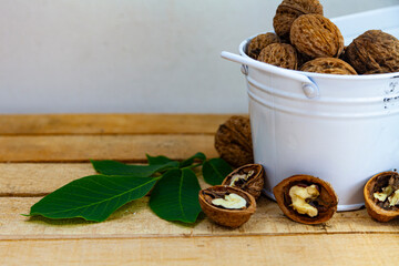 Walnuts and leaves on a wooden table.
