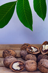 Walnuts and leaves on a wooden table.