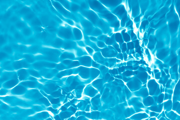 Blurred transparent blue colored clear calm water surface texture with splashes and bubbles. Trendy abstract nature background. Water waves in sunlight with copy space.