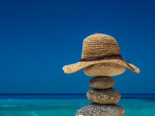 Straw Sunhat at the beach on stones