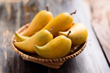 Eggfruit or canistel in a basket on wooden table, Thai fruit, In Thai names such as Xiantao, Lamut Khamen or Mon khai