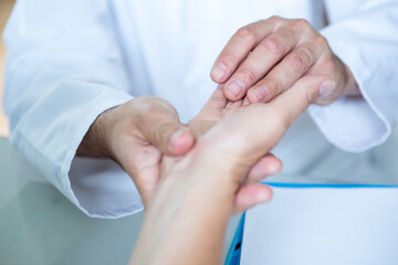 Healthcare - Orthopedist examining patients hand.