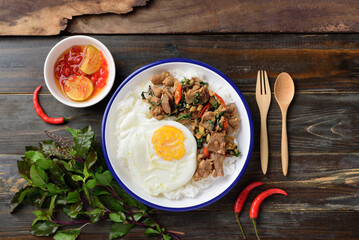 Thai food, Stir fried pork with basil and fried egg on cooked rice eating with chili in fish sauce (Pad Kaprao Moo Kai Dao)